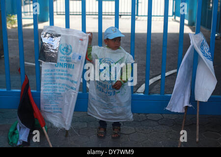 La striscia di Gaza, Territori palestinesi. 9 Apr 2014. Palestinesi prendere parte a una manifestazione di protesta contro la decisione presa dall'Ente soccorso e lavori delle Nazioni Unite (UNRWA) a ridurre le forniture di aiuto alimentare di fronte al quartier generale dell'UNRWA di Gaza City, il 9 aprile 2014. © Majdi Fathi/NurPhoto/ZUMAPRESS.com/Alamy Live News Foto Stock