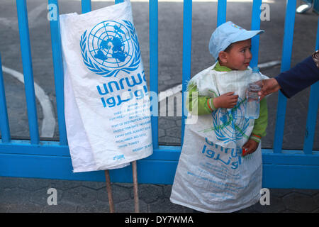 La striscia di Gaza, Territori palestinesi. 9 Apr 2014. Palestinesi prendere parte a una manifestazione di protesta contro la decisione presa dall'Ente soccorso e lavori delle Nazioni Unite (UNRWA) a ridurre le forniture di aiuto alimentare di fronte al quartier generale dell'UNRWA di Gaza City, il 9 aprile 2014. © Majdi Fathi/NurPhoto/ZUMAPRESS.com/Alamy Live News Foto Stock