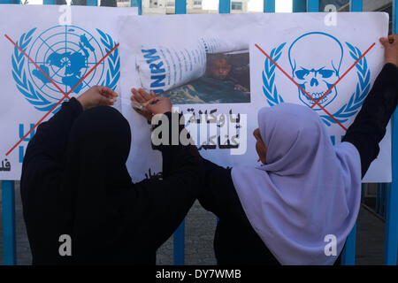 La striscia di Gaza, Territori palestinesi. 9 Apr 2014. Palestinesi prendere parte a una manifestazione di protesta contro la decisione presa dall'Ente soccorso e lavori delle Nazioni Unite (UNRWA) a ridurre le forniture di aiuto alimentare di fronte al quartier generale dell'UNRWA di Gaza City, il 9 aprile 2014. © Majdi Fathi/NurPhoto/ZUMAPRESS.com/Alamy Live News Foto Stock