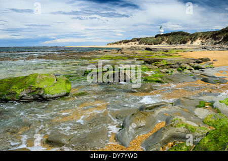 Faro di Waipapa punto con le nuvole nel cielo, alghe rocce coperte nella parte anteriore, Otara, Fortrose, Regione del Southland Foto Stock