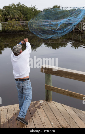 Fisherman gettando Cast Off netto Dock, FL, Stati Uniti d'America Foto Stock