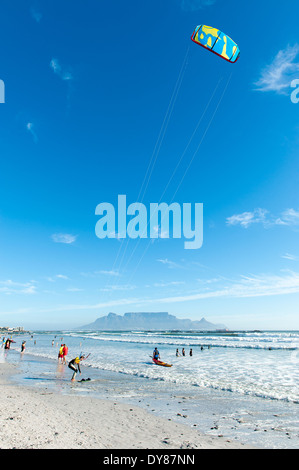 Kitesurfer preparazione al surf, Bloubergstrand, Table Mountain in background, Sud Africa Foto Stock