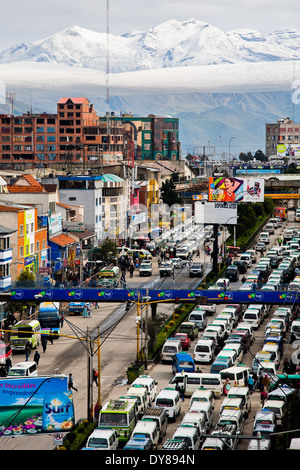 Cime coperte di neve delle Ande, con un traffico autostradale inceppamento in primo piano, sono visibili nella città di El Alto, Bolivia. Foto Stock