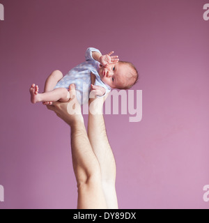 Ciao, mondo! Padre tenendo le mani a due settimana neonato Foto Stock