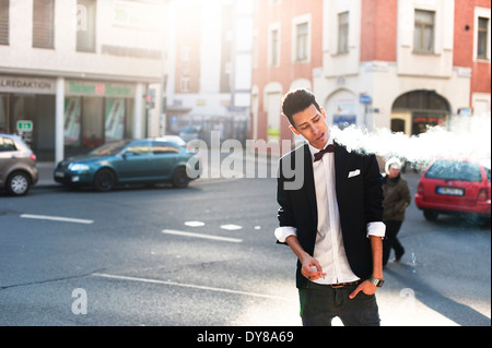 Il fumo giovane uomo nella città Foto Stock