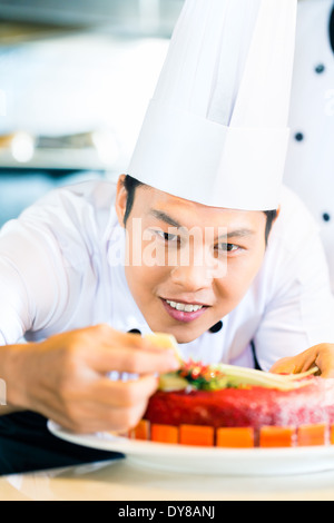 Ritratto di chef asiatico decorare la torta Foto Stock