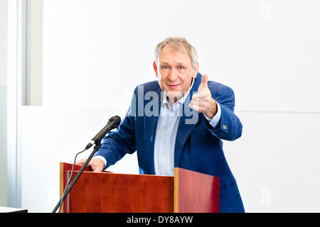 Professore universitario dando lezioni e permanente al desk Foto Stock