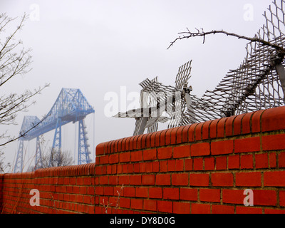 Transporter storico ponte che attraversa il Fiume Tees, dietro un muro di mattoni a Middlehaven, Middlesbrough, Teesside, England, Regno Unito Foto Stock