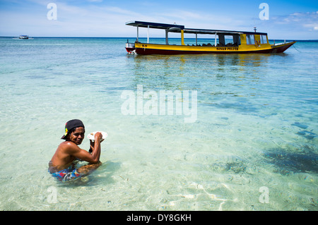 Uomo locale di mangiare in acqua, Isola Gili, Lombok, Indonesia, Asia Foto Stock