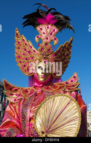 Carnevale di Venezia, primo piano ritratto di donna in maschera d'oro e costume da vestito rosa brillante, durante il carnevale di Venezia Foto Stock