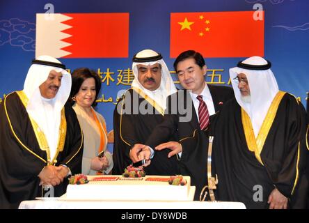 Manama, Bahrain. 9 Apr 2014. Ambasciatore cinese in Bahrain Li Chen (seconda R) taglia la torta con i funzionari del Bahrein durante un ricevimento in Manama, Bahrein, il 9 aprile 2014. Il ricevimento si è tenuto in occasione del XXV anniversario dell istituzione della i legami diplomatici tra Bahrein e Cina. © Wang Bo/Xinhua/Alamy Live News Foto Stock