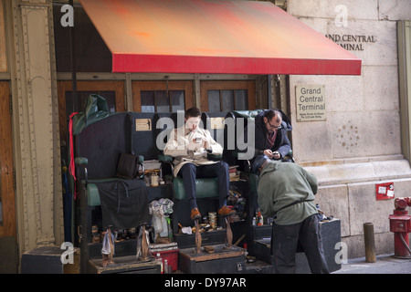 Piccola azienda di lucidatura scarpe sul marciapiede fuori Grand Central Terminal sulla 42nd St. in NYC. Foto Stock