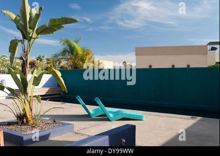 Contemporary lettini per prendere il sole in un cortile interno dell'hotel con piscina Foto Stock