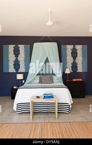 Letto matrimoniale con baldacchino netto in blu camera da letto murato con abbinamento di Floral stampare le foto Foto Stock