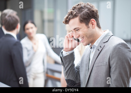 Imprenditore tramite telefono cellulare all'aperto Foto Stock