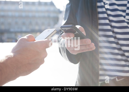 Due persone che lo scambio di informazioni via smartphone Foto Stock