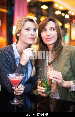 Le donne aventi un cocktail presso il bar Foto Stock