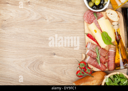 Formaggio, prosciutto, pane, spezie e verdure. Su un tavolo di legno con uno sfondo con spazio di copia Foto Stock