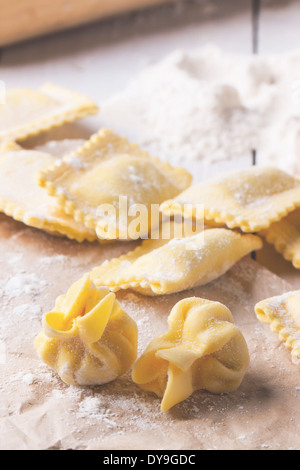 Close up di pasta fatta in casa i ravioli e perle sulla tavola con la farina. Foto Stock