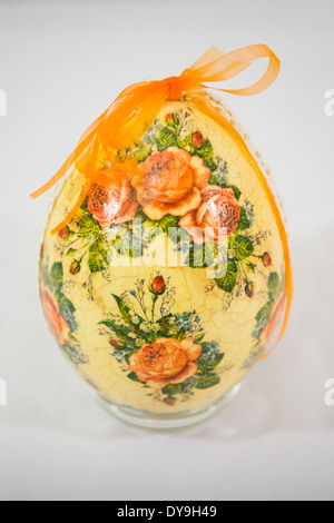 Uovo di Pasqua decorate con fiori realizzata mediante tecnica di decoupage su sfondo chiaro Foto Stock
