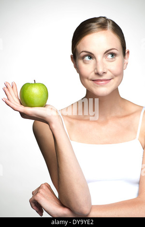 Giovane donna mantenendo la mela verde Foto Stock