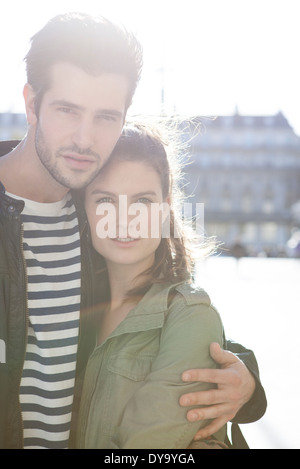 Giovane abbracciando nella città, ritratto Foto Stock