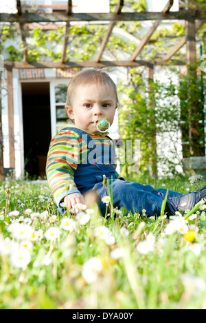 Bambino seduto in cantiere, ritratto Foto Stock