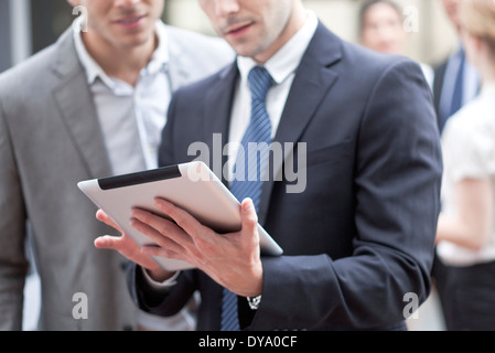 Imprenditore mostra collega tavoletta digitale Foto Stock