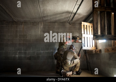 Un cecchino dalla US Army 7 Forze Speciali gruppo fa un adeguamento a un treppiede mentre il suo compagno di squadra identifica il suo bersaglio dall'interno di un edificio durante il cecchino USASOC concorrenza Marzo 26, 2014 a Fort Bragg, N.C. Foto Stock