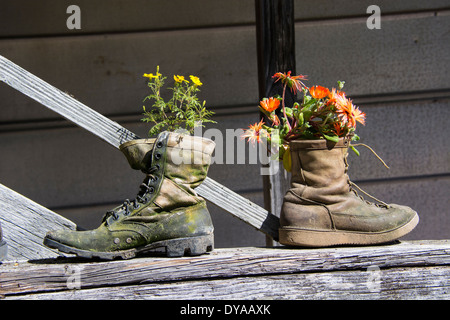 Due vecchi stivali utilizzati come caratteristico e insolito dei vasi da fiori. Upcycling, riutilizzato, Upcycle o riciclare in giardino. Foto Stock