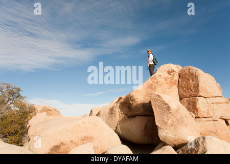 L uomo sta su massi a Joshua Tree National Park Foto Stock