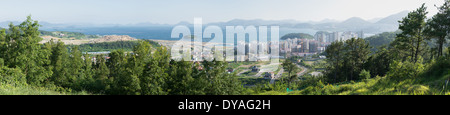 Panorama di Yeosu in Corea del sud come si vede dalle montagne circostanti con la foresta, oceano e alloggiamento sito in costruzione Foto Stock