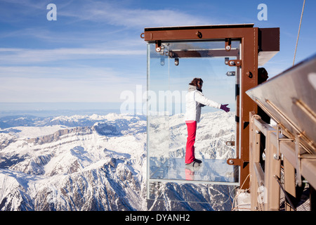 Un turista si erge nel 'Step nel vuoto' box di vetro sulla Aiguille du Midi (3842m) mountain top sopra Chamonix Monte Bianco Foto Stock