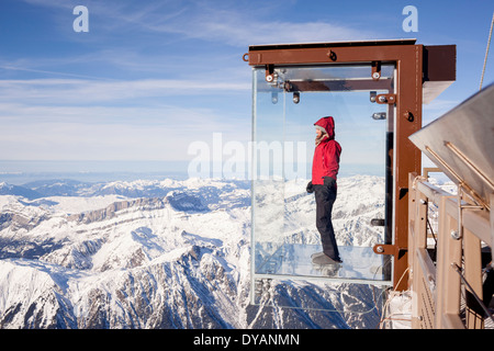 Un turista si erge nel 'Step nel vuoto' box di vetro sulla Aiguille du Midi (3842m) mountain top sopra Chamonix Monte Bianco Foto Stock