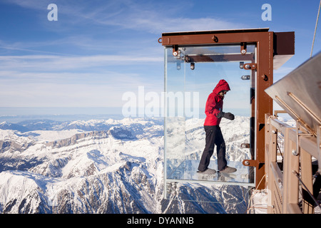 Un turista si erge nel 'Step nel vuoto' box di vetro sulla Aiguille du Midi (3842m) mountain top sopra Chamonix Monte Bianco Foto Stock
