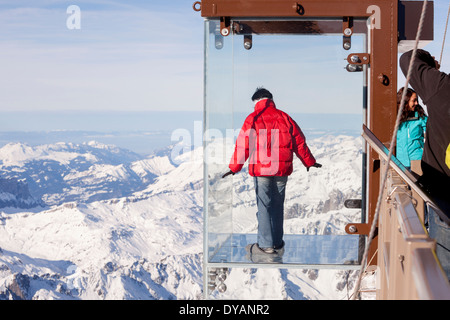 Un turista si erge nel 'Step nel vuoto' box di vetro sulla Aiguille du Midi (3842m) mountain top sopra Chamonix Monte Bianco Foto Stock