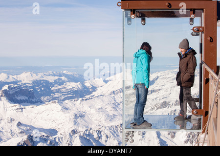 I turisti si erge nel 'Step nel vuoto' box di vetro sulla Aiguille du Midi (3842m) mountain top sopra Chamonix Monte Bianco Foto Stock