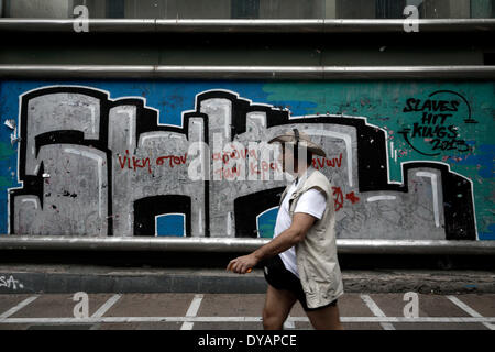 Atene, Grecia. Xi Apr, 2014. Un uomo cammina passato un graffito che recita "la vittoria nella lotta dei prigionieri' ad Atene in Grecia il 11 aprile 2014. Credito: Konstantinos Tsakalidis/Alamy Live News Foto Stock