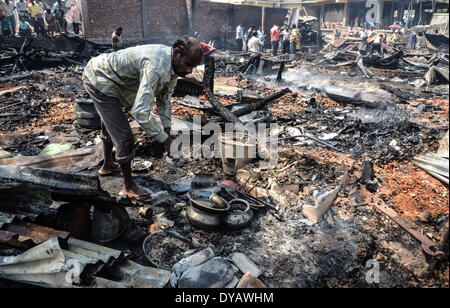 Dimapur, India. Xii Apr, 2014. Un indiano residente recuperare la loro appartenenza dopo un incendio senza visceri giù molte case residenziali al segnale Bosti in Dimapur, India nord orientale di stato del Nagaland, sabato 12 aprile, 2014. Migliaia di persone sono state rese senzatetto nelle prime ore del mattino inferno in un luogo residenziale, funzionario detto. Credito: Caisii Mao/NurPhoto/ZUMAPRESS.com/Alamy Live News Foto Stock