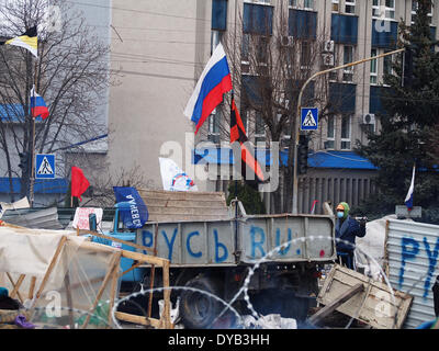 Lugansk, Ucraina. Xii Apr, 2014. Un uomo si erge su una barricata in ucraino ufficio regionale del servizio di sicurezza in Luhansk Credit: Igor Golovnov/Alamy Live News Foto Stock