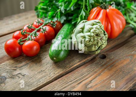 Pomodori a grappolo, inglese i cetrioli, i carciofi e prezzemolo. Foto Stock