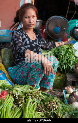 Donna verdure di vendita nel mercato a Kratie, Cambogia Foto Stock