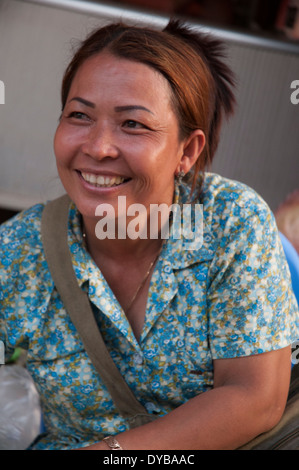 Donna sorridente stallholder nel mercato a Kratie, Cambogia Foto Stock