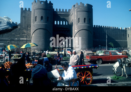 Una scena di strada con Bab al Futah, Bab al Futuh (porta di conquista) una delle tre porte rimanenti nelle mura della città vecchia del Cairo, Egitto. Fu terminata nel 1087 e si affaccia a nord. Foto Stock