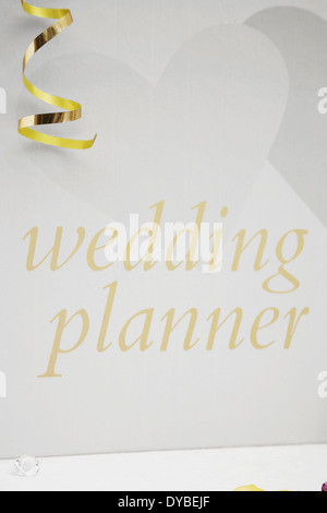 Wedding planner prenota su una tovaglia bianca con archi,argento cuore coriandoli e piccolo diamante tabella decorazioni Foto Stock