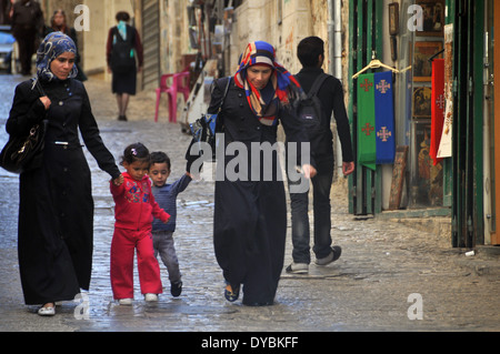 Due donne e due bambini di camminare lungo un vicolo del quartiere musulmano, la città vecchia di Gerusalemme, Israele Foto Stock