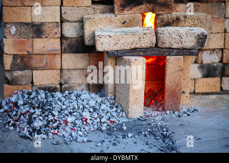 Forno di mattoni. Una manciata di carbone vicino alla stufa Foto Stock