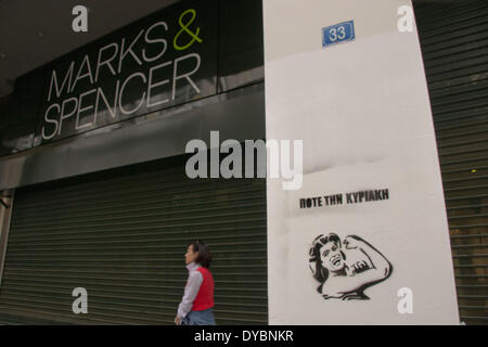 Atene, Grecia. Xiii Apr, 2014. L'ingresso di un Marks & Spencer shop è visto chiuso mentre su foregrounfd uno stencil è visto che recita "Mai (lavoro) domenica " . Una fase di protesta contro l'apertura di negozi di Domenica e l'estensione del loro orario di lavoro ad Atene' quartiere centrale dello shopping on April 13, 2014. Credito: PACIFIC PRESS/Alamy Live News Foto Stock