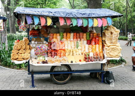Coloratissima street food cart visualizza attraente confezionati junk food snack considera compresi i lecca lecca gigante nel Chapultepec Park Foto Stock