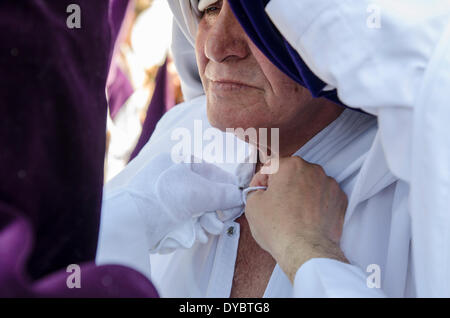 Siviglia, Spagna. Xiii Apr, 2014. I penitenti della fratellanza di 'La Estrella " Regolazione della tunica. Celebrazione cristiana dove la morte e la risurrezione di Gesù Cristo è celebrato. Credito: Kiko Jimenez/Alamy Live News Foto Stock